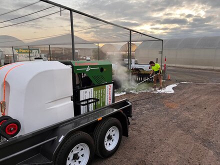 Pracownik w odzieży ochronnej podczas mycia wysokotemperaturowego